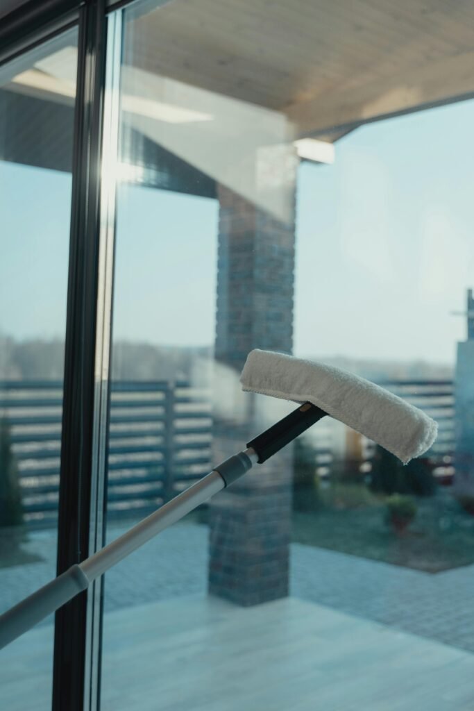 pexels-photo-6195105-6195105 A modern cleaning tool used to clean a large glass window with a clear outdoor view.