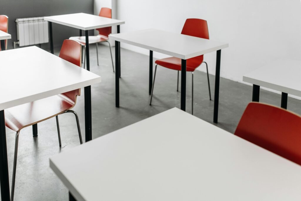 classroom Minimalist classroom setup with red chairs and white desks, ideal for educational themes.